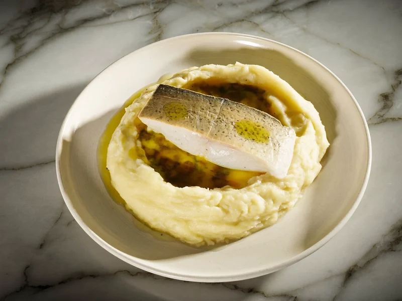 Purè di patate cremoso con filetto di pesce al vapore e olio d'oliva